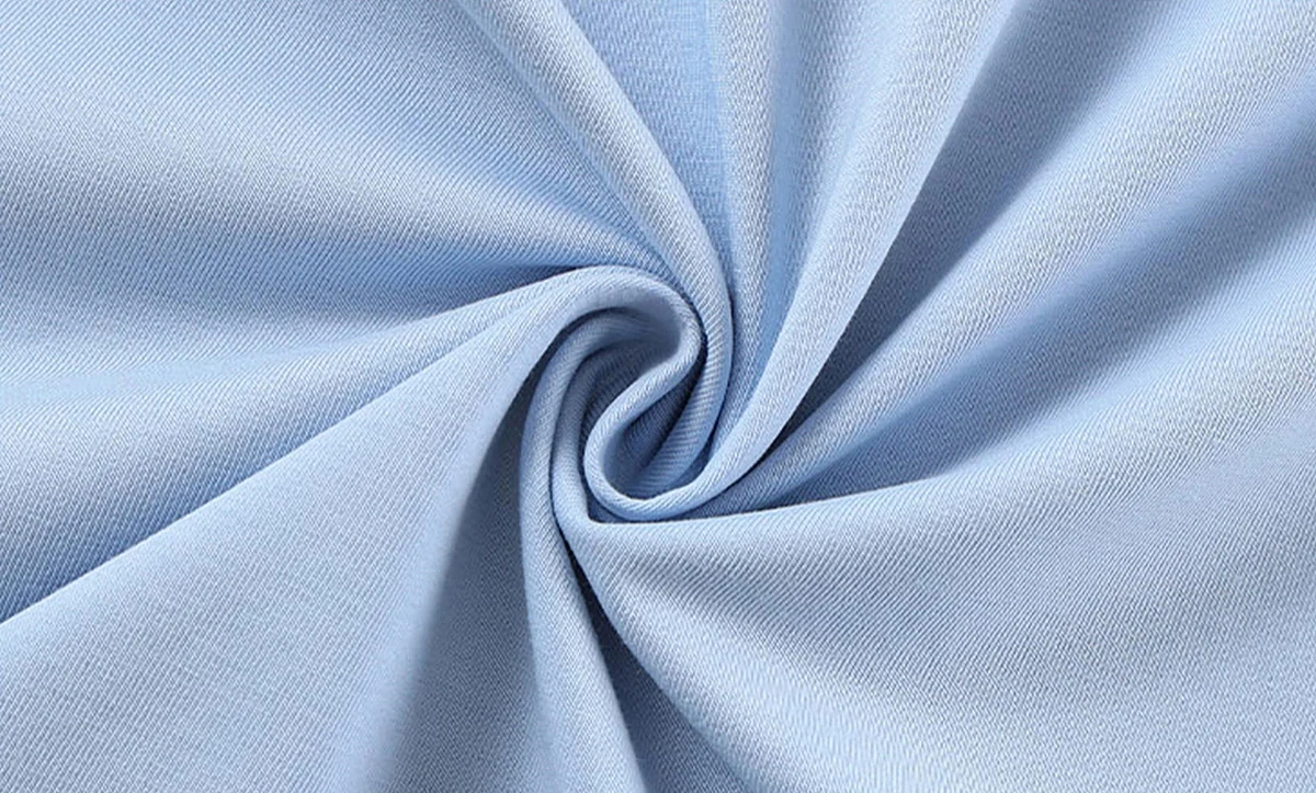 Close-up of a blue SORONA cooling T-shirt fabric with ultrafine details, featuring thin lines on the side and top. The gradient light blue hue enhances photorealism. Made from heavyweight cotton blend, it offers UV protection, ideal for daily commutes with comfort and style.
