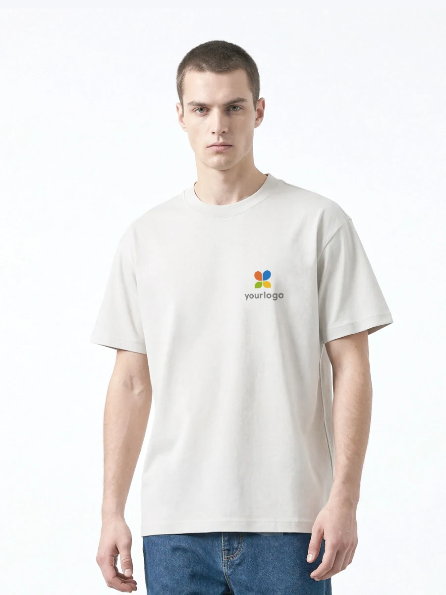 Man wears a beige white t-shirt with a colorful custom logo on the chest, paired with blue jeans. The minimalist, suprematist-style artwork features a rainbow logo. Designed for casual wear, this 21-count double yarn short-sleeve shirt suits outdoor activities, daily commuting, and modern techwear fashion.